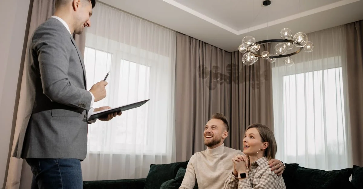 Un couple rencontrant un agent immobilier discutant de biens dans un salon moderne.