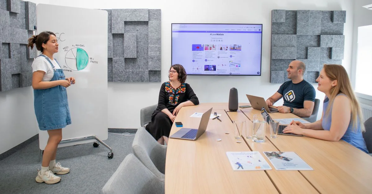 Équipe collaborant lors d'une réunion avec présentation et discussion dans un bureau moderne.