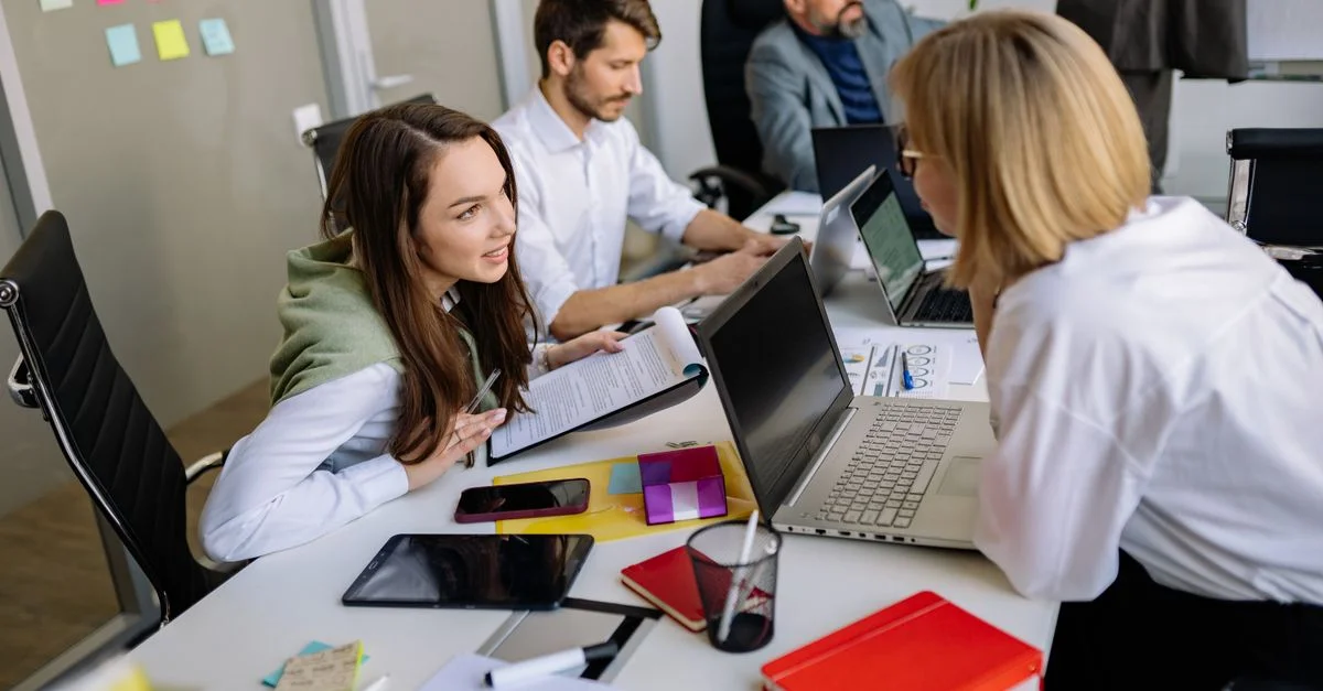 Discussion d'équipe dans un cadre de bureau moderne, axée sur la coopération et le développement de stratégies.